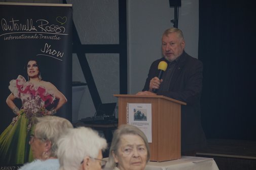 Im Vordergrund Mitglieder und der Vorsitzende (links ein Plakat von der Show)