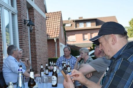 Menschen sitzen mit Kaltgetränken an einem Tisch