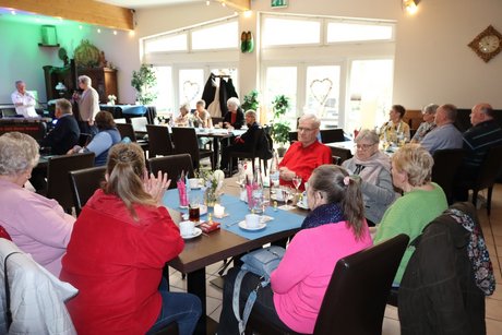 Frühlingsfest Mehrere Menschen sitzen an Tischen und unterhalten sich.