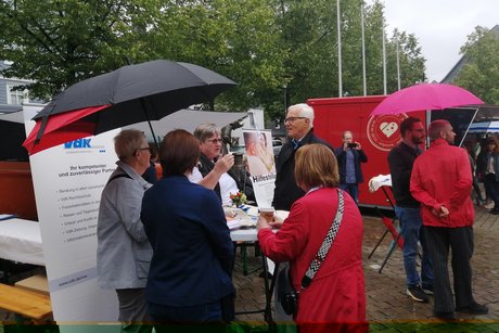 Bei Nieselregen dann eben unterm Regenschirm; reges Interesse am Infostand des VdK Ortsverband Olpe.