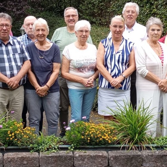 Die Vorstandsmitglieder des Kreisverbands Dortmund stehen als Gruppe hinter bepflanzten Blumenk&uuml;beln.