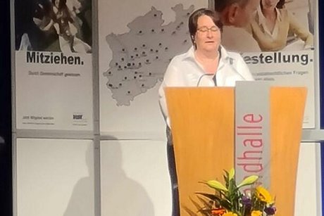 Katharina Batz steht an einem blumengeschmückten Rednerpult.