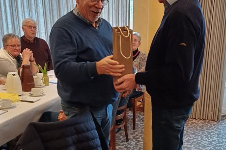 Der Vorsitzende überreicht ein Präsent am zurückgetretenen Vorsitzenden