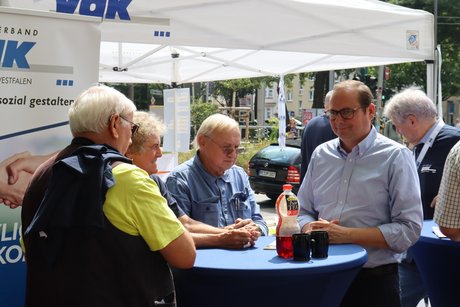 Mehrere Personen stehen um einen Stehtisch und unterhalten sich mit dem Oberbürgermeister der Stadt Essen Thomas Kufen.