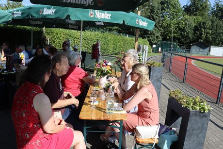 Mehrere Personen sitzen im Biergarten.
