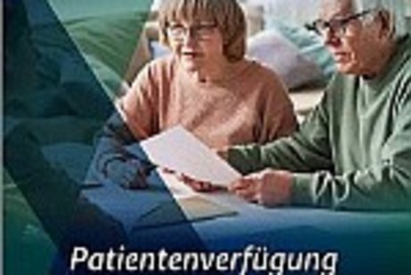 das Bild zeigt ein Ehepaar über eine Patientenverfügung gebeugt