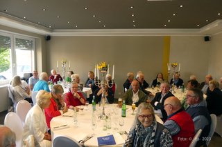 Menschen sitzen um runde Tische im Restaurant