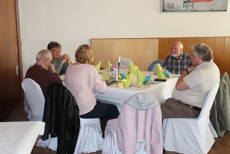 Jahreshauptversammlung 2026 Mehrere Personen sitzen an einem großen Tisch und unterhalten sich.