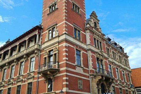 Das Rathaus von Leer ist aus roten Ziegeln und hellen Sandsteinen gebaut und hat einen hohen Turm mit Kupferdach und Rathausuhr.