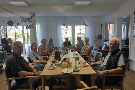 Zwei Männer und sechs Frauen beim Kaffeeklatsch