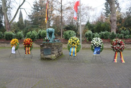 Mehrere Kränze sind vor dem Ehrenmal aufgestellt.