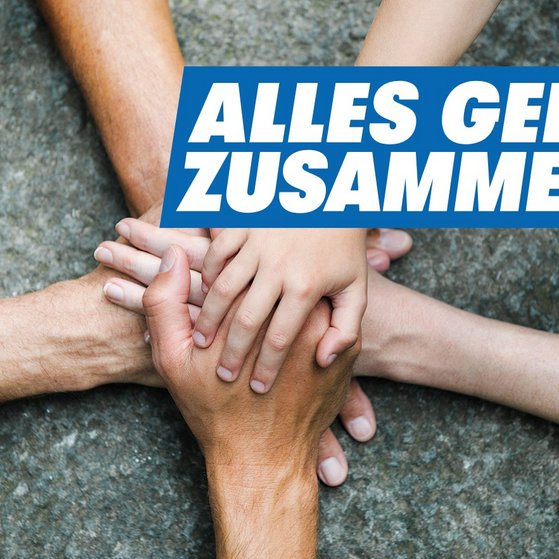 Fünf Arme ragen aus fünf Richtungen ins Bild, die Hände sind in der Bildmitte auf einem grauen Untergrund übereinandergelegt. Oben rechts in weißer Schrift auf blauem Grund: Alles geht zusammen.