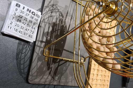 Bingo-Spielger&auml;t mit Kugeln und Spielbl&ouml;cke sind auf einem Tisch abgebildet