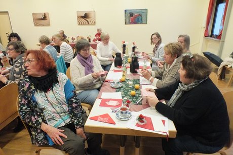 Jahresabschlusstreffen der Frauenvertreterinnen. Mehrere Frauen sitzen an langen Tischen und basteln.