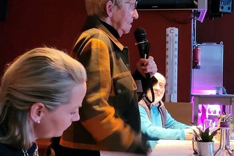 Carola Fuhlrott steht mit Mikrofon in der Hand und hält eine Rede.