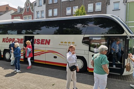 Mehrere Personen stehen vor dem Reisebus.