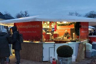 Der heimelig beleuchtete Glühwein-Stand der Stiftung Schloss Dyck versorgt die durstigen Weihnachtsmarkt-Besucher mit Heißgetränken.