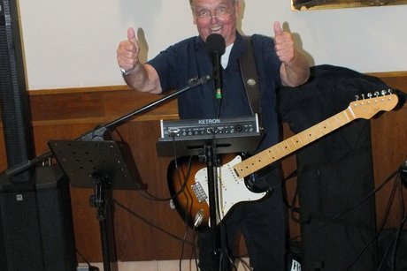 Ein Mann mit Gitarre singt .