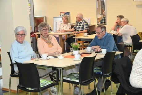 Mitglieder sitzen an einem Tisch und unterhalten sich