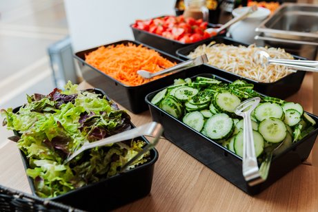 Salatbuffet mit Schalen mit Blattsalat, Gurken, M&ouml;hren, Tomaten und Krautsalat