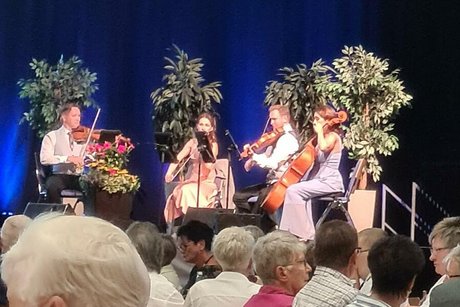 Ein Streichquartett musiziert gemeinsam auf einer Bühne.