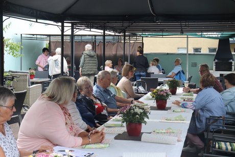 Grillnachmittag vom VdK Ortsverband Borbeck gemeinsam mit dem Ortsverband Altendorf. Teilnehmer sitzen an langen Tischen unter einem Pavillon.