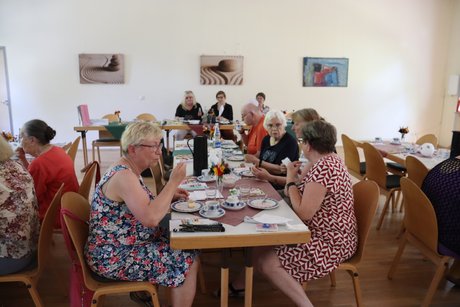 Treffen der Vertreterinnen der Frauen. Mehrere Frauen sitzen an einem langen Tisch.