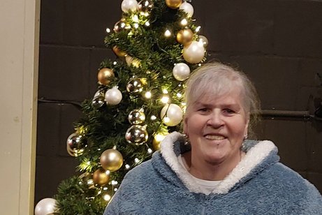 Frau Angelika Aretz mit einem Weihnachtsbaum im Hintergrund