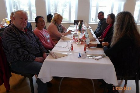 Eine Gruppe Menschen sitzt gemeinsam an einem Tisch.