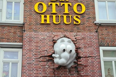 Ein von Comedian Otto entworfener "Ottifant" bricht als Skulptur aus der Ziegelmauer eines Hauses. Darüber ist in großen gelben Buchstaben die Aufschrift "Dat Otto Huus" angebracht.