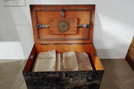 Alte Holztruhe mit losen Papieren