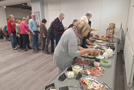 Zu sehen ist das reichhaltige Buffet und etliche Gäste die bereits in der Warteschlange anstehen.