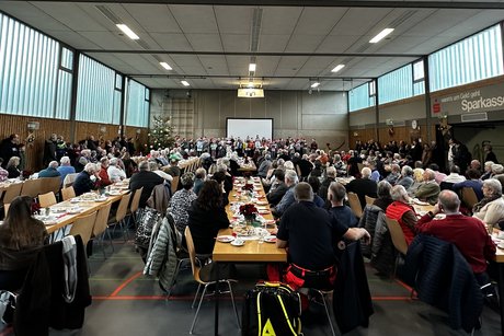 Halle mit Menschen an Tischen mit weihnachtlicher Dekoration
