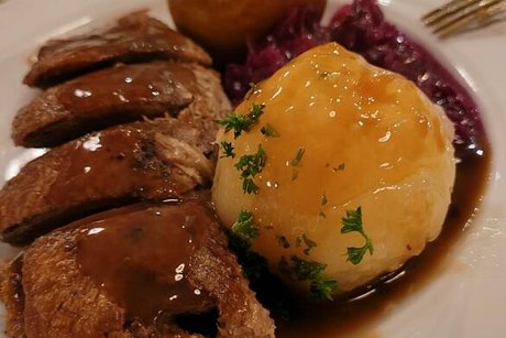 Teller mit Rotkohl, Braten und Kloß.
