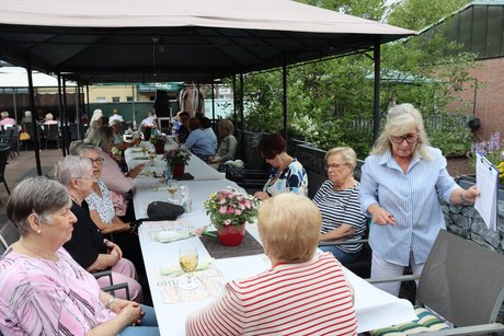 Grillnachmittag vom VdK Ortsverband Altendorf gemeinsam mit dem Ortsverband Borbeck. Die Teilnehmer sitzen an einem langen Tisch unter einem Pavillon im Außenbereich.