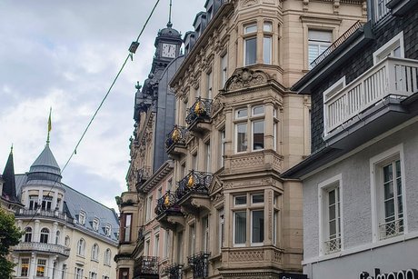 Das Bild wird dominiert von einer herrlichen Hausfassade aus der Kaiserzeit. Sie zeigt den Reichtum der Stadt auch in der Fussgängerzone.