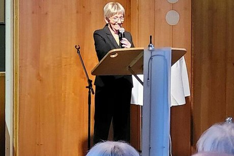 Carola Fuhlrott steht mit Mikrofon am Rednerpult.