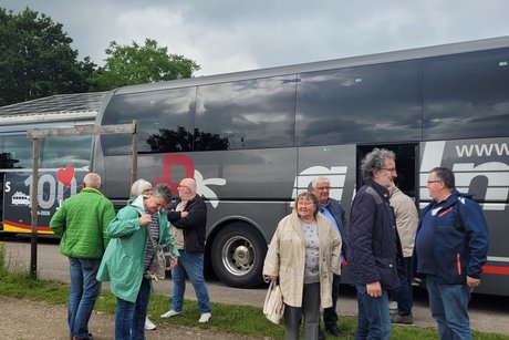 Ein paar Personen stehen an einem Bus