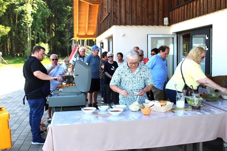 Mitglieder am Grillbuffet Mitglieder stehen am Grillbuffet
