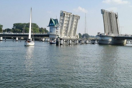 Die mehrspurige Zugbrücke über der Schlei ist geöffnet, um ein Segelschiff durchfahren zu lassen.