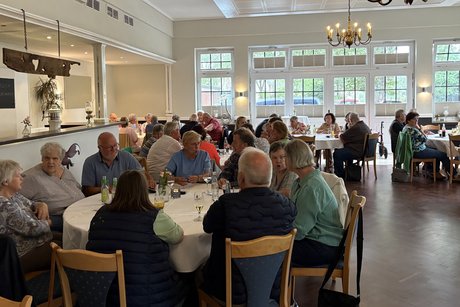 Sommerfest 2026 mehrere Tische in einem Saal sind mit Personen besetzt