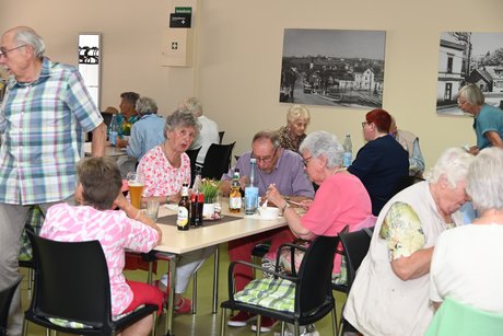 Menschen sitzen am Tisch beim Essen