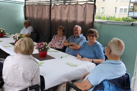 Grillnachmittag vom VdK Ortsverband Borbeck gemeinsam mit dem Ortsverband Altendorf. Teilnehmer sitzen an einem langen Tisch unter einem Pavillon.