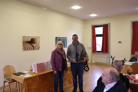 Eine Frau &uuml;bergibt ein Pr&auml;sent an einen Mann.