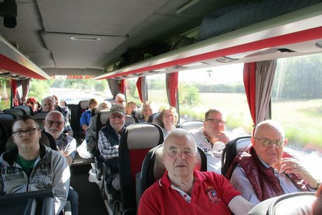 Eine Gruppe Menschen sitzt gemeinsam im Reisebus.