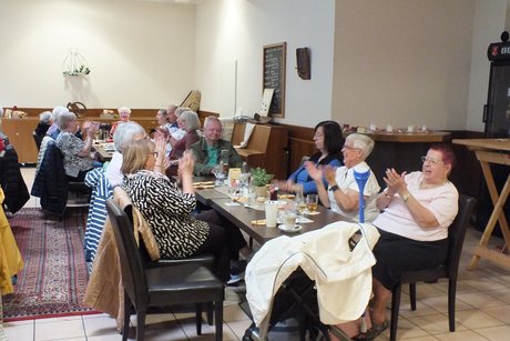 Mehrere Menschen singen und klatschen in die H&auml;nde.