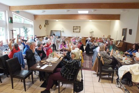 Mitglieder und G&auml;ste folgen den Anweisungen des Musikers und singen mit.