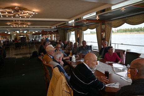 Teilnehmer auf dem Schiff beim gemeinsamen Mittagessen