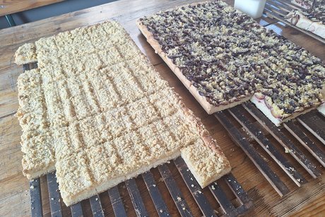 Das Bild zeigt zwei gro&szlig;e Platten Zwetschen- und Apfelstreuselkuchen frisch aus dem Ofen.
