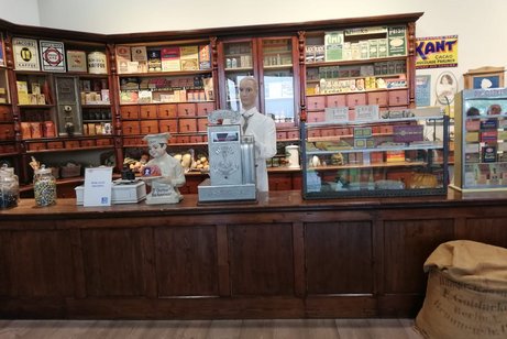 Das Foto zeigt einen Verkäufer und seinen Lehrling als Figuren in einem historischen Kaufladen bei Dr. Oetker in Bielefeld.